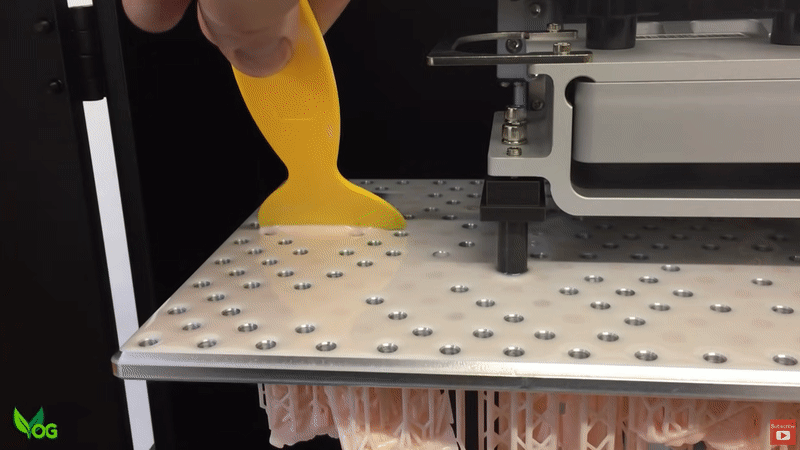 Removing excess resin from the building plate