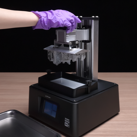A picture showing a 3D printer in the process for removing the build plate