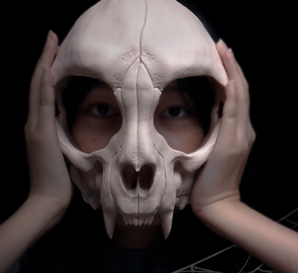 A picture of a girl wearing a 3d printed skeletal cosplay mask with huge fangs