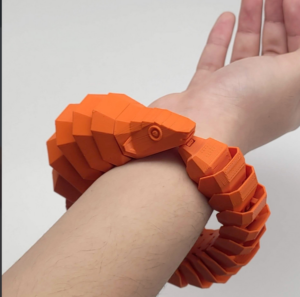 A cool 3d print of an orange pangolin bracelet wit scaley design.