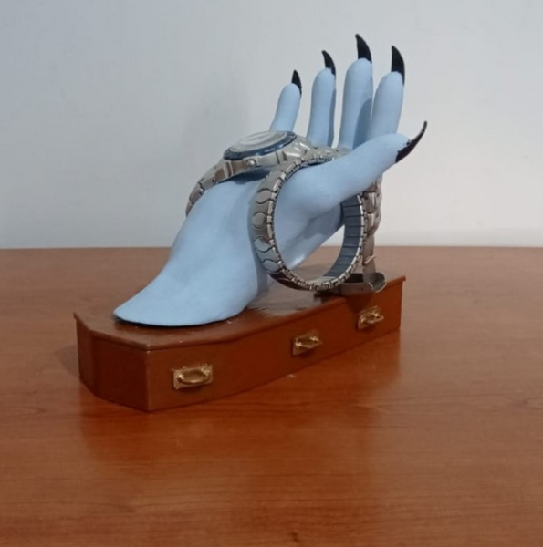 A spooky 3D-printed jewelry holder shaped like a skeletal hand on a coffin-shaped base, perfect for storing rings and bracelets.
