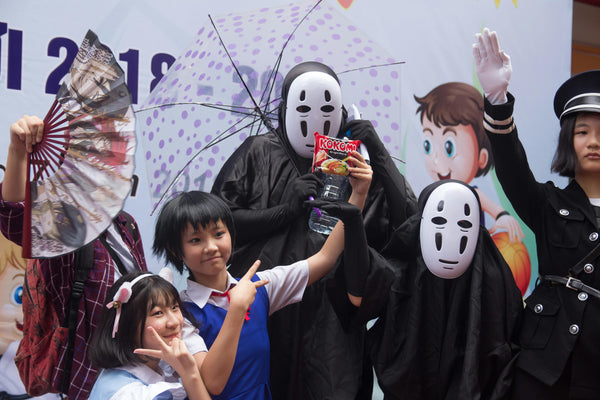 A picture of a few japanese people in no face cosplay