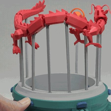 A cool 3d print featuring a red dragon chasing and playing with an orange pear automata.