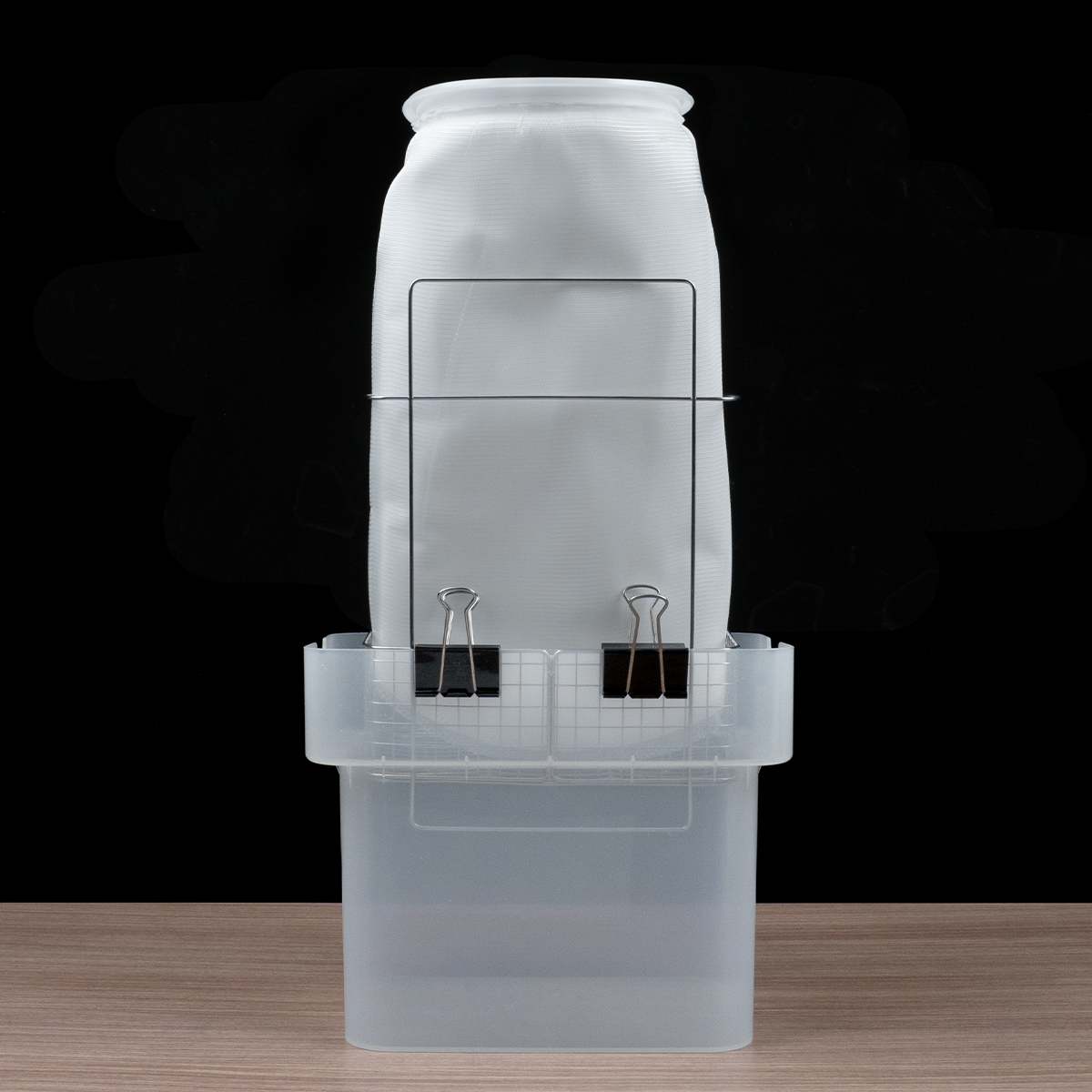 Phrozen Alcohol Filter Bag clipped securely to a plastic container, showing an easy setup for collecting filtered alcohol.