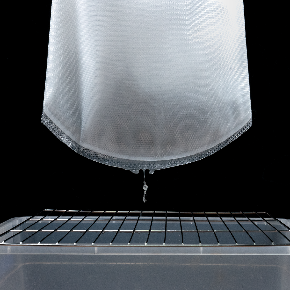 Cloudy used alcohol dripping through the Phrozen Alcohol Filter Bag into a clean container, capturing resin residue during filtration.