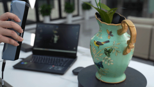 Person using the EINSTAR 3D scanner to scan a vase with flowers with reliable high-speed scanning and intelligent tracking.