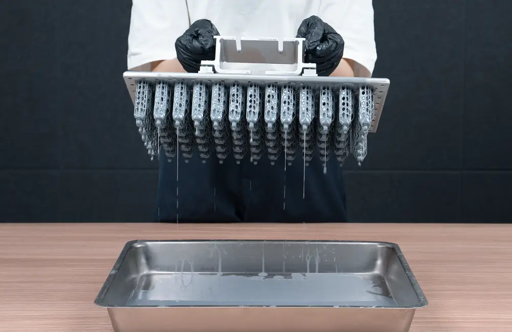 Build plate with printed models dripping resin above a tray without the built-in drip hanger.