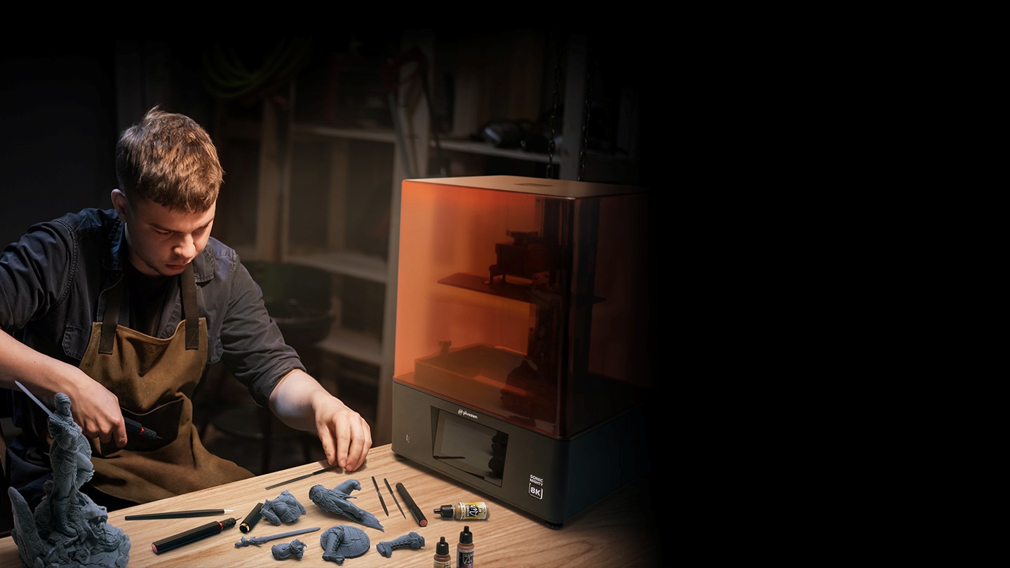 Creator preparing printed models beside the Phrozen Sonic Mighty 8K for high-productivity 3D printing.