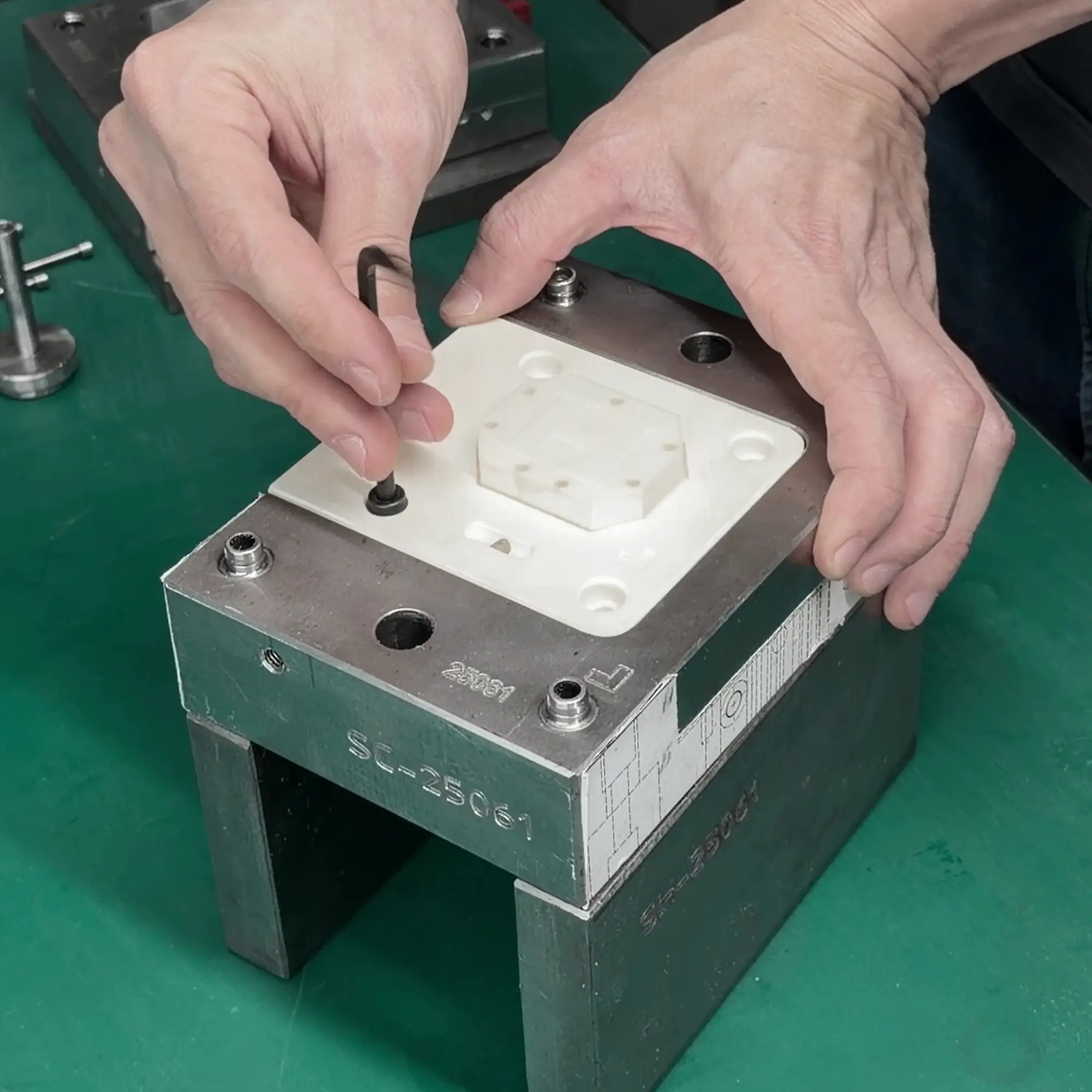 Hands installing a 3D printed mold insert made with Ceramic Pro Resin into a metal mold base.